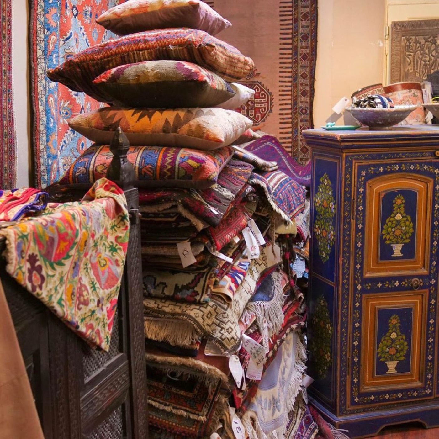 Stacked kilims, cushions and painted chests inside the gallery
